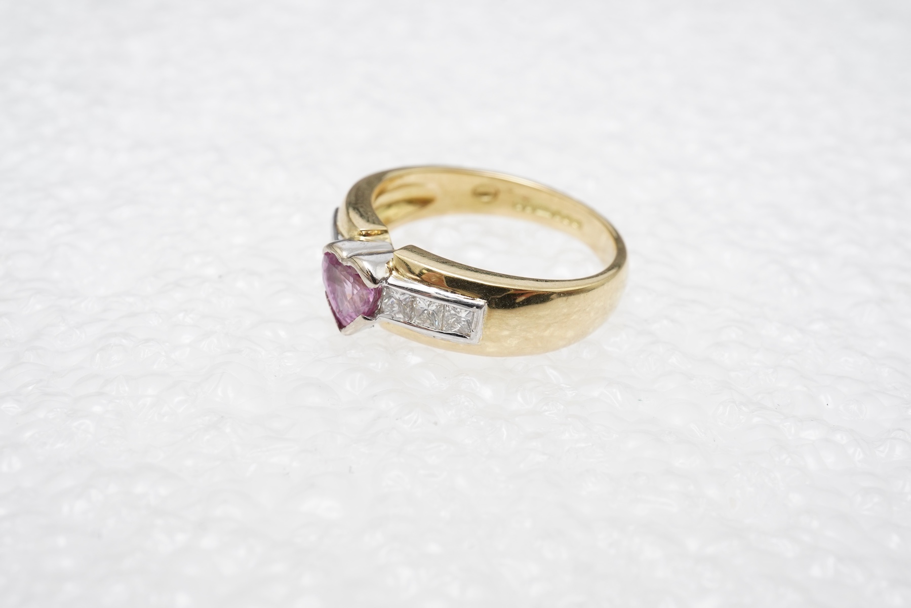 A pink sapphire and diamond ring